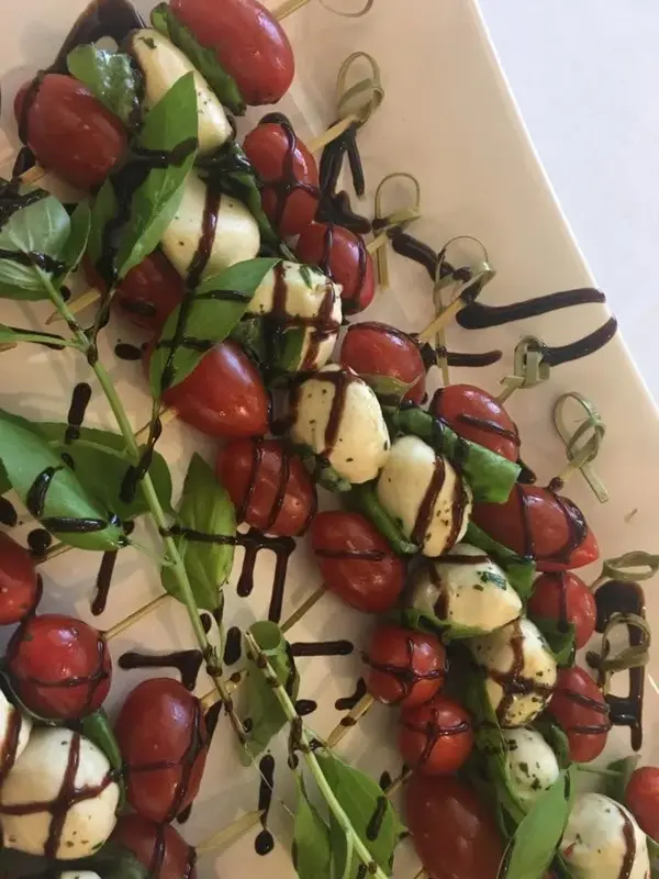 Caprese skewers with tomato and mozzarella, drizzled with balsamic