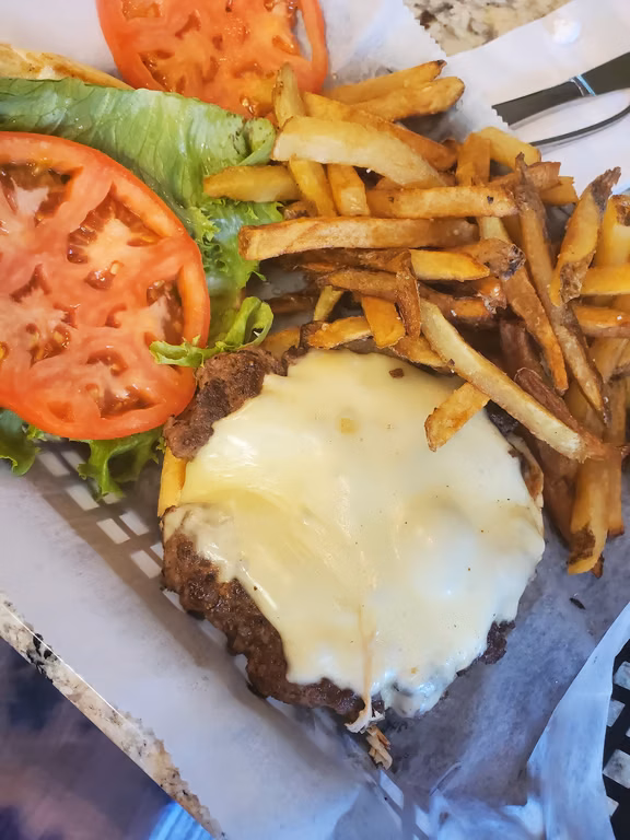 Cheeseburger with hand-cut fries and a tomato slice