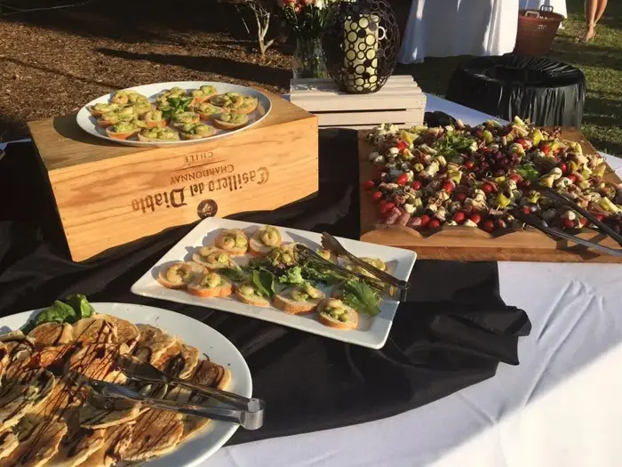 Catering buffet with appetizer platters and a berry salad